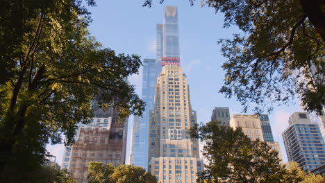 Majestuoso-Edificio-Del-Hotel-Marriott-Essex-House-Con-Vistas-Al-Parque-Central-En-La-Mañana-Soleada,-Ciudad-De-Nueva-York-Manhattan-Usa,-Rodeado-De-Modernas-Torres-Del-Centro,-Vista-De-ángulo-Bajo-Desde-El-Parque-Central