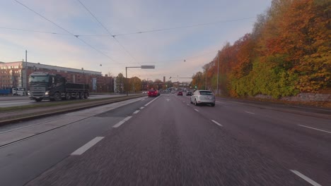 Fall-morning-commute-POV:-Driving-into-city-beside-railway-tracks