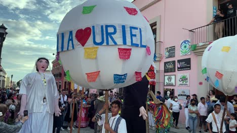 slow-motion-shot-of-a-traditional-wedding-celebration-in-the-city-of-oaxaca-with-hot-air-balloons-and-the-bride's-mannequin-in-the-public-street