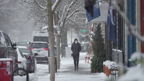 Foto-De-Una-Mujer-Envuelta-Caminando-Por-Una-Acera-Llena-De-Nieve-En-La-América-Rural