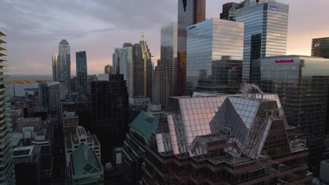 Aerial-view-in-front-of-the-downtown-Toronto-skyline,-sunny-evening-in-Canada---ascending,-drone-shot