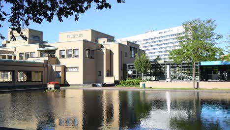 THE-HAGUE,-31-July-2020---Reflection-on-the-pond-of-Museon-view-from-the-shade-of-trees,-The-Hague-municipality-modern-art-museum-in-the-Netherlands