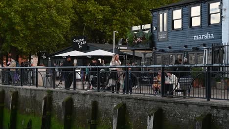 People-walking-past-Gourmet-Pizza-and-Marsha-in-Southbank,-London,-United-Kingdom