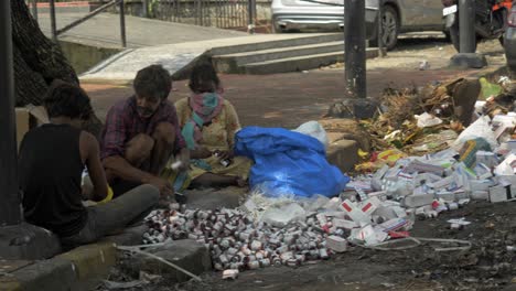 Toma-Estática-De-Un-Grupo-De-Traperos-Asiáticos-Desechando-Medicamentos-Vencidos,-Tabletas,-Jarabes-En-Medio-De-La-Basura-Seca-De-La-Ciudad