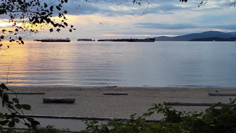 Silhouette-Of-Barges-On-The-English-Bay-At-Dusk-In-Vancouver,-Canada-With-Active-People-Jogging-In-Foreground