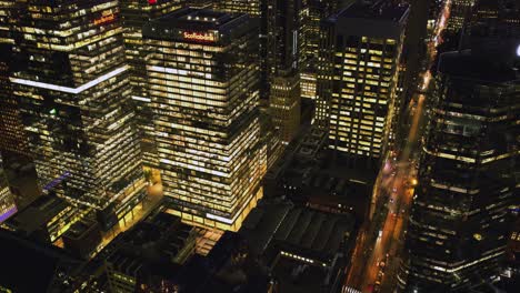 Hiperlapso-De-Inclinación-Aérea-Del-Tráfico-Y-Rascacielos-Iluminados-De-Noche-En-La-Ciudad-De-Toronto,-Canadá