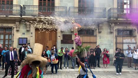 slow-motion-shot-of-an-indigenous-woman-with-the-traditional-costumes-of-oaxaca-and-fireworks-on-her-head-during-a-wedding-celebration-in-the-city-of-oaxaca-mexico,-dancing-in-the-street