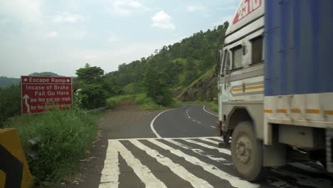 Rampa-De-Escape-De-Tiro-Estático-Cerca-De-Frenos-De-Velocidad-Y-Camiones-Que-Cruzan-La-Carretera-Rodeada-De-Montaña