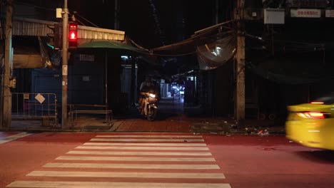 Scooter-coming-out-of-a-small-alley-trying-to-get-in-to-the-traffic-in-Bangkok,-Thailand-during-the-pandemic