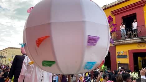 Toma-En-Cámara-Lenta-De-Una-Boda-Tradicional-En-La-Ciudad-De-Oaxaca-Con-Globos-Aerostáticos-E-Invitados-Bailando-En-La-Calle