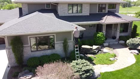 Drone-shot-of-a-Gutter-inspection-from-a-ladder-by-a-handy-man-carpenter