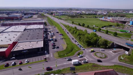 Rotating-aerial-shot-of-cars-driving-around-a-roundabout-and-along-the-highway