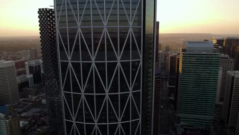 Vista-Aérea-Frente-Al-Edificio-Del-Arco-En-El-Centro-De-Calgary,-Puesta-De-Sol-En-Canadá---Ascendente,-Disparo-De-Drones