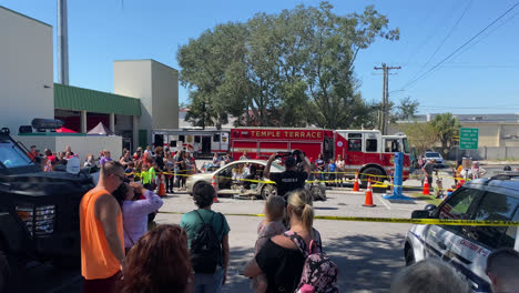 A-police-officer-talking-to-a-crowd-of-adults-and-kids-at-a-public-demonstration-and-showing-crowd-different-equipment-at-a-fire-and-safety-event-in-Tampa,-Florida