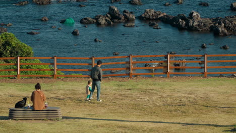 Retrato-De-Una-Familia-En-Un-Parque-Costero-De-Jaguri-Con-Rocas-Volcánicas-En-La-Isla-De-Jeju,-Seogwipo,-Corea-Del-Sur