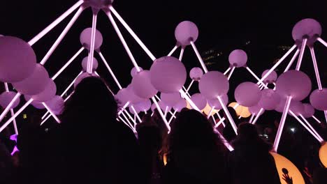 Silhouette-people-interact-with-touch-illuminated-Affinity-neuron-artwork,-Chavasse-park,-Liverpool-River-of-light