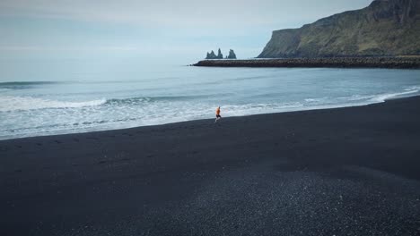 Kamerafahrt-Eines-Sportlichen-Mannes,-Der-Am-Magischen-Schwarzen-Sandstrand,-Island,-Läuft