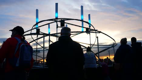 La-Audiencia-De-La-Silueta-Interactúa-Con-La-Obra-De-Arte-De-La-Neurona-Del-Looper-De-La-Luz-Espiral-Iluminada,-El-Evento-Del-Río-De-La-Luz-De-La-Cabeza-Del-Muelle-De-Liverpool-Al-Atardecer