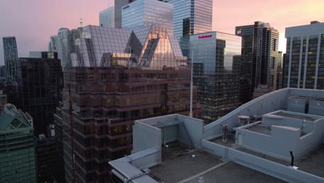 Aerial-view-rising-close-to-reflecting-windows,-revealing-the-Toronto-skyline,-during-dusk