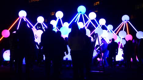 People-interact-with-fluorescent-Affinity-neuron-artwork,-Chavasse-park,-Liverpool-River-of-light