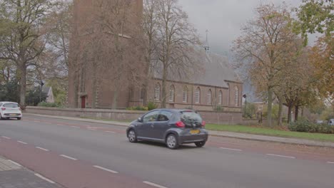 Autos-Fahren-An-Einem-Schönen-Herbsttag-Am-Alten-Kirchengebäude-Vorbei