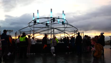 La-Multitud-Interactúa-Con-La-Obra-De-Arte-De-La-Neurona-Del-Looper-De-Luz-Espiral-Iluminada,-Evento-Del-Río-De-La-Luz-De-La-Cabeza-Del-Muelle-De-Liverpool-Al-Atardecer