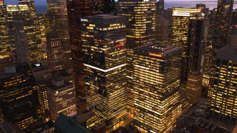 Hyperlapse-drone-shot-of-traffic-and-illuminated-skyscrapers-in-downtown-Toronto,-dusk-in-Ontario,-Canada