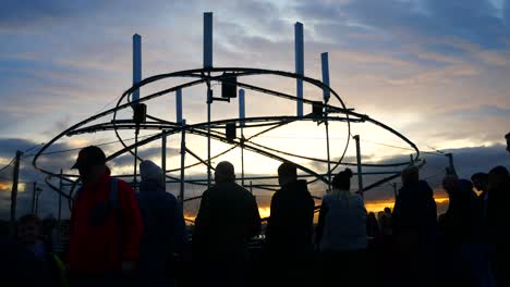 La-Silueta-Del-Público-Interactúa-Con-La-Obra-De-Arte-De-La-Neurona-Del-Looper-De-Luz-Espiral-Iluminada,-El-Evento-Del-Río-De-La-Luz-De-La-Cabeza-Del-Muelle-De-Liverpool-Al-Atardecer