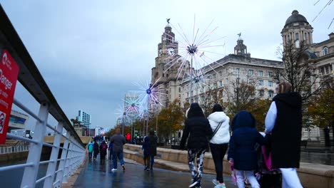 Menschen,-Die-Rund-Um-Blinkende,-Neonelektrische-Löwenzahn-Kunstwerke-Am-Liverpooler-Pier-Head-River-Of-Light-Ereignis-An-Der-Uferpromenade-Des-Lebergebäudes-Sehenswürdigkeiten-Besichtigen