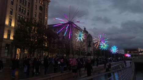 Audiencia-Reunida-En-Torno-A-La-Obra-De-Arte-De-Diente-De-León-Eléctrico-De-Neón-Intermitente-En-El-Evento-River-Of-Light-De-Liverpool-Pier-Head