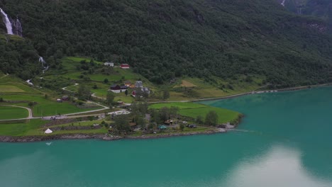 Yrineset-Camping-Am-Oldevatn-gletschersee-Im-Alten-Norwegen---Antenne-über-Dem-See-Mit-Blick-Auf-Einen-Fantastischen-Campingplatz-Mit-Wasserfällen-Und-üppigen-Berghängen-Im-Hintergrund