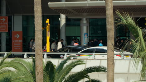 Crowd-Of-Passengers-And-Cars-At-The-Jeju-International-Airport-In-Jeju-City,-South-Korea-During-Daytime