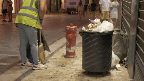 Weibliche-Straßenkehrmaschine,-Die-Abfälle-Aus-überfüllten-Mülleimern-Auffegt