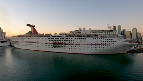 Luxus-Kreuzfahrtschiff-Carnival-Ecstasy-Angedockt-Am-Hafen-Mit-Stadtbild-Skylinen-Im-Rücken-|-Kreuzfahrtschiff-Angedockt-An-Backbord-Videohintergrund-In-4k