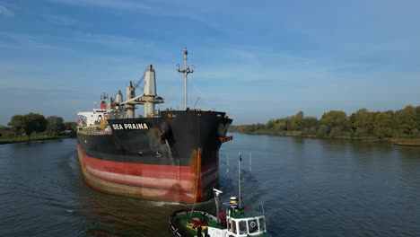 Paralaje-Aéreo-Alrededor-Del-Remolcador-Que-Ayuda-Al-Granelero-Prajna-Del-Mar-Mientras-Navega-A-Lo-Largo-De-Oude-Maas