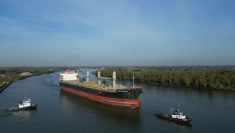 Luftaufnahme-Von-Schleppern,-Die-Sea-Prajna-Bulk-Carrier-Entlang-Der-Oude-Maas-In-Puttershoek-Unterstützen