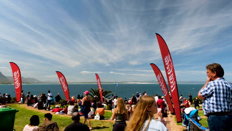 Tourists-at-Hermanus-Whale-Festival,-wispy-clouds-in-blue-sky