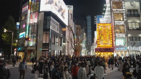 In-Downtown-Shinjuku-Japan,-People-Cross-Street-Towards-Kabukicho