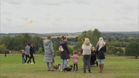 Madres-Con-Niños-Se-Quedaron-Mirando-Cometas-Volando-En-Un-Festival-De-Cometas-En-Heath-Common-Wakefield,-Aburrido-Día-De-Primavera