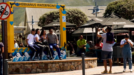 Turistas-Haciendo-Recuerdos---Fotos-Tomadas-En-El-Marco-Amarillo-Frente-Al-Mar-De-Hermanus