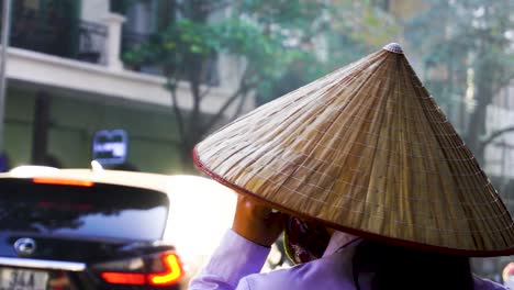 Pov-Caminando-Por-Una-Mujer-Vietnamita-Tradicional-Con-Sombrero-Cónico-De-Paja-Hablando-Por-Teléfono-Móvil-En-La-Calle-Con-El-Resplandor-Del-Sol