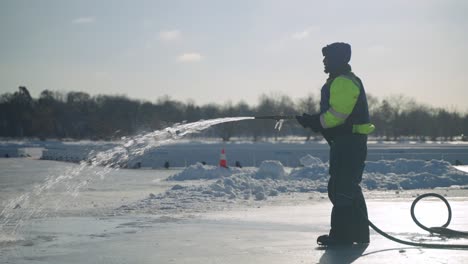 Wartungsarbeiter,-Der-Wasser-Auf-Die-Eisbahn-Sprüht,-Um-Die-Oberfläche-Zu-Glätten