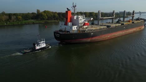 Tug-Boat-Attached-To-Stern-of-Sea-Prajna-Bulk-Carrier-As-It-Navigates-Along-Oude-Maas