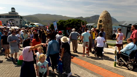 Visitors-in-Hermanus-around-historic-War-Memorial-and-naval-guns,-Whale-Festival