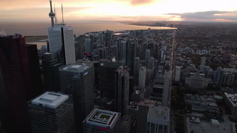 Aerial-view-overlooking-the-Fashion-District-and-the-old-Toronto-skyline,-sunset-in-Ontario,-Canada---tracking,-drone-shot