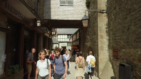 Gente-Abarrotada-En-La-Concurrida-Calle-Del-Pueblo-De-Le-Mont-saint-michel-En-Manche,-Normandía,-Francia