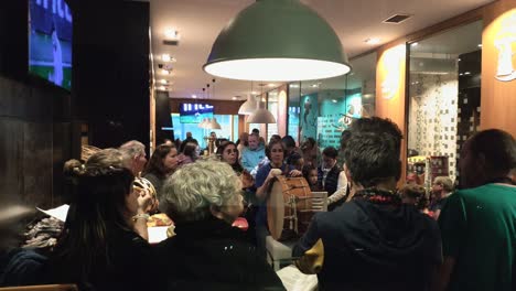 musicians-with-instruments-taking-a-break-in-a-busy-bar-with-live-music,-lots-of-people-enjoying-at-the-end-of-the-week,-spotted-shot-out-of-focus,-Ordes,-Galicia,-Spain