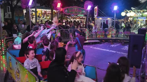 San-Froilán-Carnival-at-nighttime,-people-having-fun-riding-Toy-train-Playground,-Lugo-City,-Spain