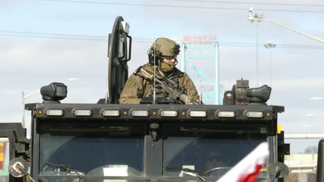 RCMP-tac-cop-holding-weapon-on-tank-top-during-freedom-convoy-prostests-in-Windsor,-Canada