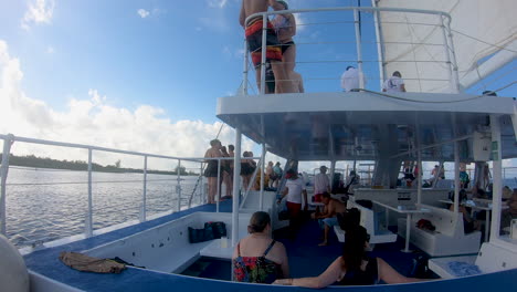 Cozumel,-mexico,-12-11-2022,-people-enjoy-catamaran-ride-during-sunset-in-Caribbean-sea-in-Mexico,-a-group-of-people-travelling-in-catamaran-sail-boat-video-in-4k